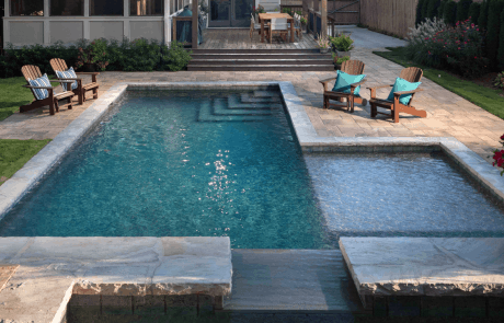 Custom outdoor living space features a backyard retreat with a wealth of options for outdoor dining, entertaining, swimming, and lounging poolside.