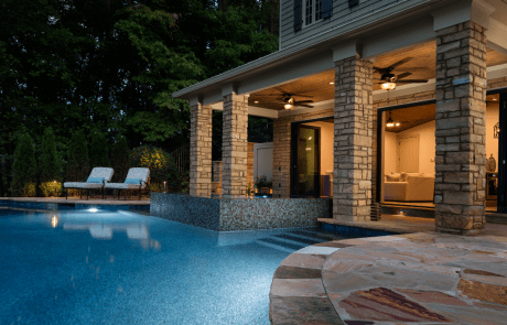 Traditional style pool house overlooks the incredible infinity edge pool and negative knife edge spa with features that include large accordion doors that open the entire width of the space and create a spectacular setting for indoor-outdoor entertaining.