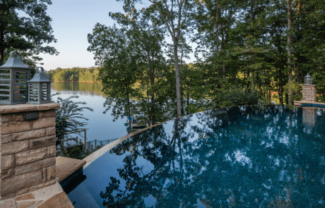 Perched high above Lake Lanier, this stunning infinity edge pool was custom designed to take advantage of the breathtaking views and its natural surroundings. Irregular Tennessee flagstone pool coping and stacked stone pedestals highlight the pool’s reflective beauty and gorgeous dark blue water.