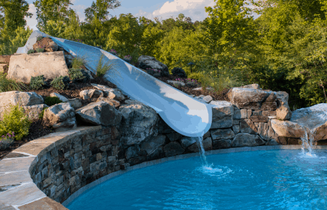 Tennessee flagstone and fieldstone boulders create the raised area for the water slide in this Atlanta swimming pool design.