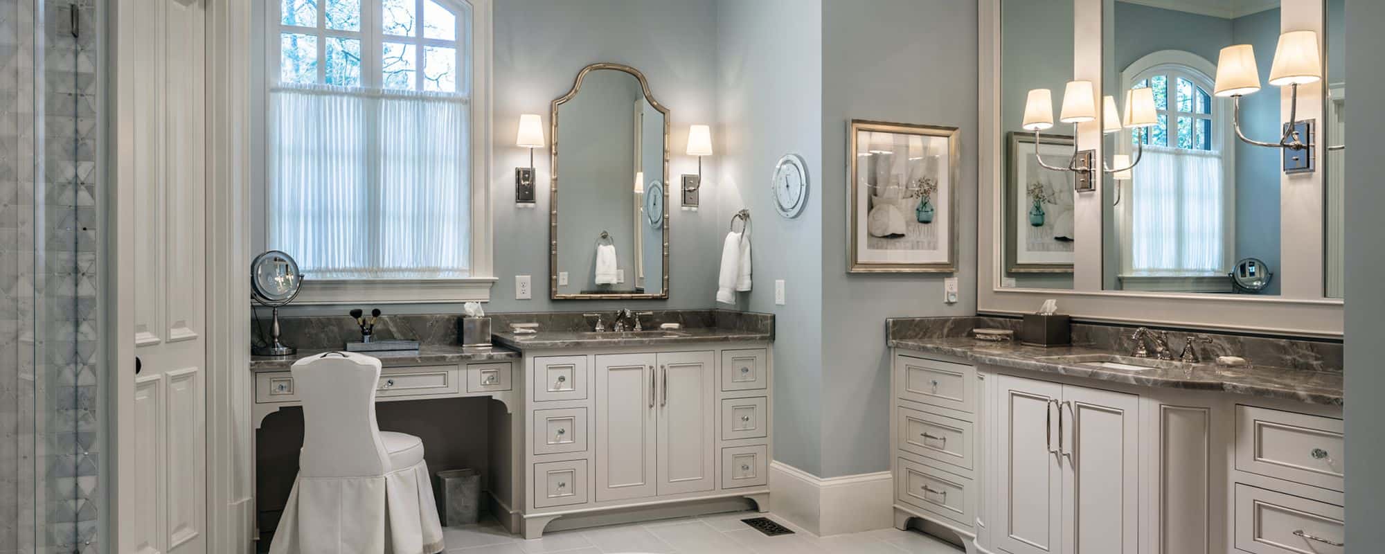 Luxury Bathroom with white cabinets and large mirrors