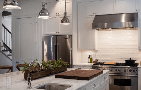 Chef’s kitchen features a large island with prep sink, white shaker cabinets, marble counter-tops, white subway tile backsplash, polished nickel pendant lights and commercial grade Viking appliances.