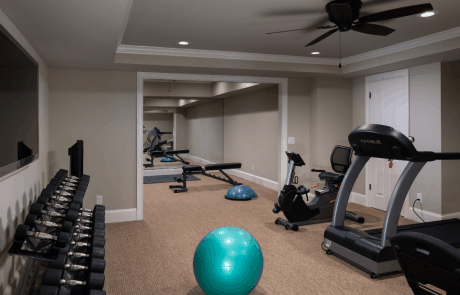 This basement remodel in Johns Creek, GA features a custom home gym that is large enough to accommodate all your fitness needs including a treadmill, stationary bike, weight bench, weight rack and separate yoga room with floor to ceiling mirrors and wall mounted tv.