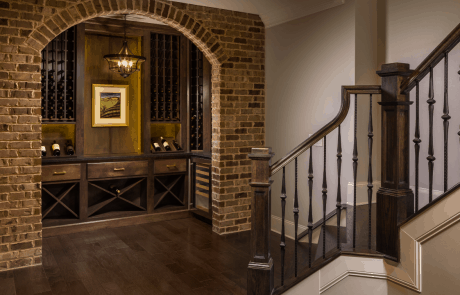 A totally remodeled staircase with new balusters, stair treads, and an expanded opening creates a dramatic entrance into this custom basement renovation.
