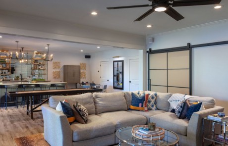 Basement Remodel with Kitchen, Bar Island w/Seating, Charcoal Cabinets, Caesarstone Quartz Countertops, Stainless Steel Appliances, Mirrored Backsplash, Floating Shelves, Brass Pendant Lights, Custom Shuffleboard Table and Metal & Glass Barn Doors.