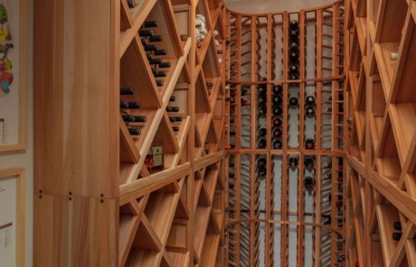 Basement Renovation with custom wine cellar is ideally located for climate and light control. The custom built-in shelving artfully displays our clients’ wine collection.