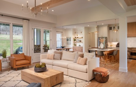 The bright and spacious open concept floor plan houses the kitchen, dining room and living areas and perfectly blends the warm wood tones, neutral colors, and natural textures throughout creating a cohesive and comfortable space for this family to relax and entertain.
