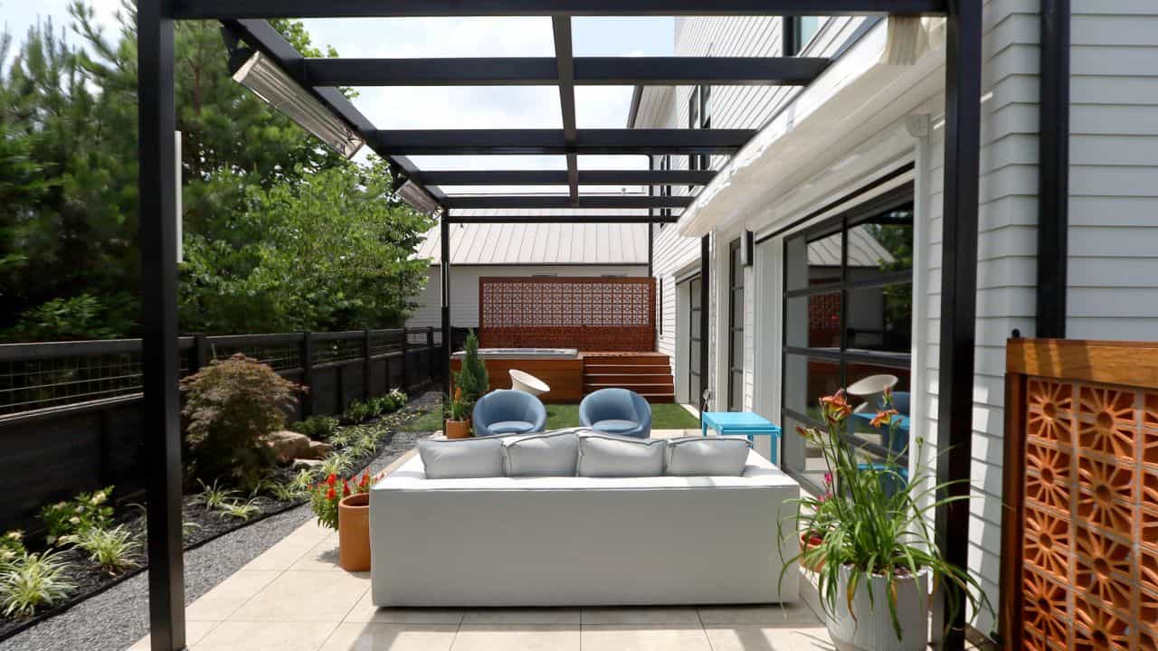 Modern outdoor living space with black steel pergola, porcelain paver patio, hot tub with Ipe decking, Breeze Block screen walls, Zen garden walkway, modern landscape design, artificial turf.