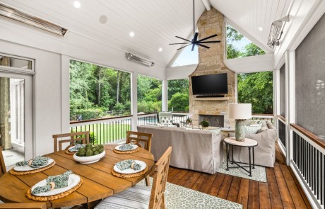 Custom built screened in porch with comfortable seating, a beautiful limestone fireplace, white tongue & groove vaulted ceilings, dark oak stained floors and uninterrupted views of the surrounding landscape.