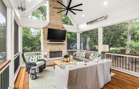 Outdoor living space with custom screened porch addition includes spacious outdoor dining & lounge areas, mounted tv, outdoor limestone fireplace with limestone mantle & limestone hearthstone, white vaulted tongue & groove ceiling, dark oak stained floors & ceiling mounted infrared heaters.