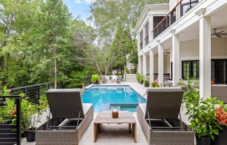 Ray-37A-Gallery Contemporary poolside living with a sleek infinity-edge pool, limestone patio, and covered lounge area by Boyce Design + Build