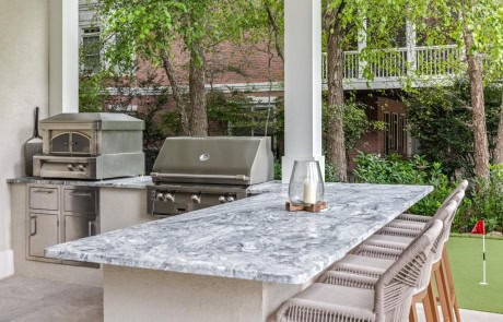 Ray-40-Gallery Outdoor kitchen with granite countertops, stainless appliances, and bar seating near infinity-edge pool.