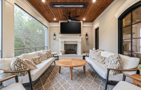 Ray-49-Gallery Elegant screened porch with limestone fireplace, mounted TV, and cozy seating.
