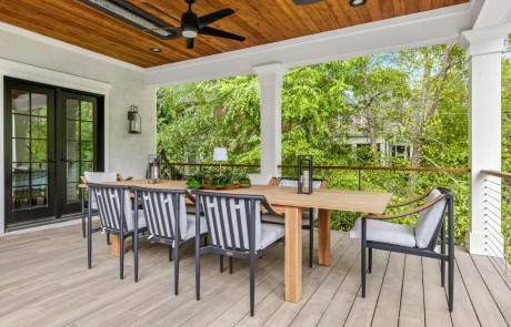 Ray-52-Gallery Covered dining porch with wood ceiling, large dining table and ceiling heaters overlooking modern backyard design.